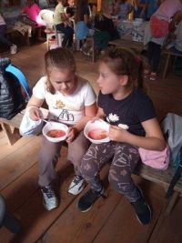 Dziewczynki jedzą przyrzadzony przez siebie kisiel owocowy